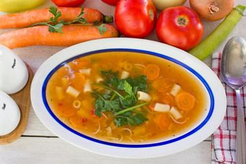 Minestrone soup in plate on white wooden table