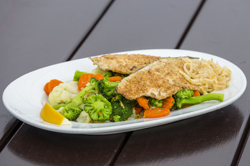 Fish fillet with broccoli, white cabbage and carrot, close up