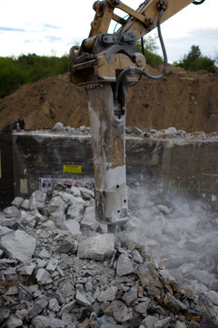 hammer drill demolishing old bridge, dust, stones and bricks  all over the place, 