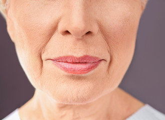 Obraz premium Closeup view of beautiful elderly woman on gray background