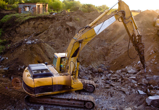 close up of excavator bucket isolated , sunny evening sky in the background, picture taken on a building site during demolishing work 