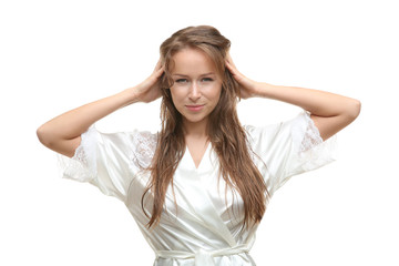 Fototapeta premium Beautiful young woman in silk bathrobe after shower on white background
