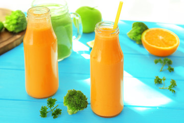 Fresh smoothies with fruits and vegetables on table