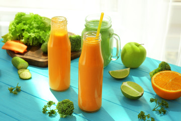 Fresh smoothies with fruits and vegetables on table