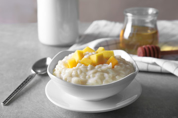 Delicious breakfast with rice pudding and fruit on kitchen table