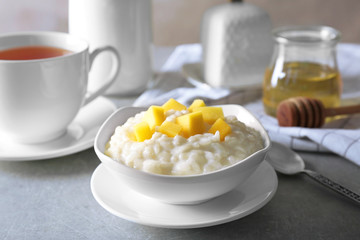 Delicious breakfast with rice pudding and fruit on kitchen table