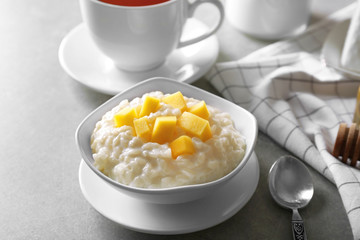 Delicious breakfast with rice pudding and fruit on kitchen table