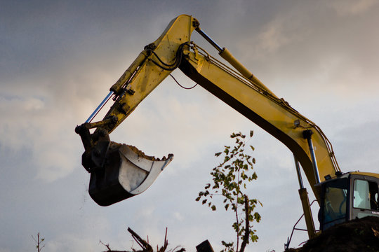 close up of excavator bucket isolated , sunny evening sky in the background, picture taken on a building site during demolishing work 