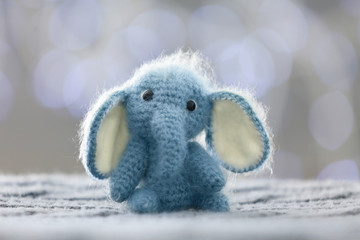 Knitted toy elephant on blurred background