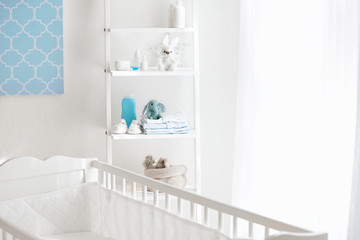 Fototapeta na wymiar Beautiful light room with crib and toys on shelves