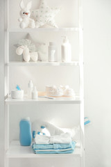 Fototapeta na wymiar Shelves with toys and baby accessories in room