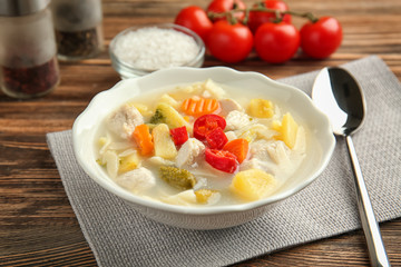 Bowl with delicious turkey soup on wooden table