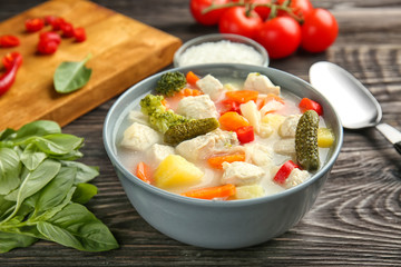 Bowl with delicious turkey soup on wooden table