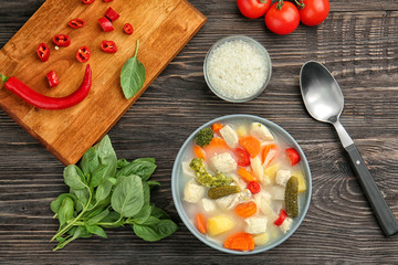 Composition with delicious turkey soup on wooden table