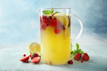 Jug with delicious strawberry lemonade on table