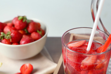 Glass with delicious strawberry lemonade on blurred background, closeup