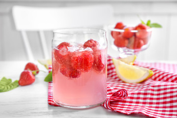 Jar with delicious strawberry lemonade on light table