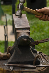 Farrier or blacksmith making horseshoes on an anvil