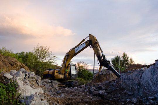 close up of excavator bucket isolated , sunny evening sky in the background, picture taken on a building site during demolishing work 
