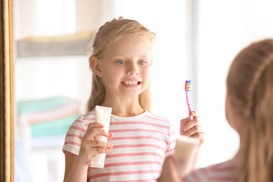Cute little girl with toothbrush and paste at home. Cleaning teeth concept