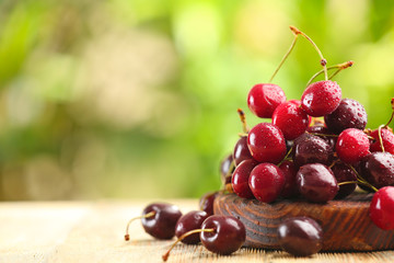 Fresh ripe cherry on wooden table outdoors