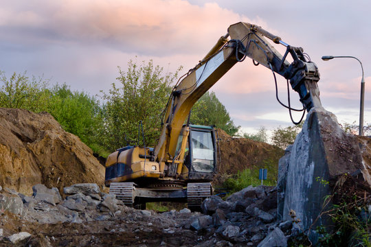 close up of excavator bucket isolated , sunny evening sky in the background, picture taken on a building site during demolishing work 