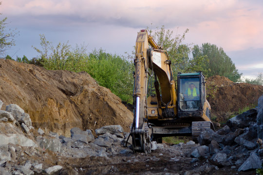 close up of excavator bucket isolated , sunny evening sky in the background, picture taken on a building site during demolishing work 