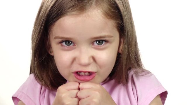 Child is angry, she is very nervous. . White background. Close up. Slow motion