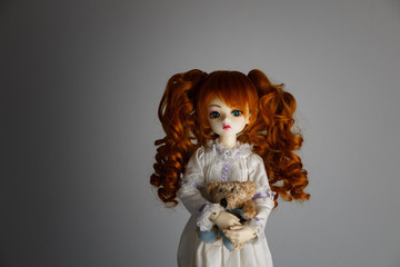 A doll with lush red hair in an antique dress