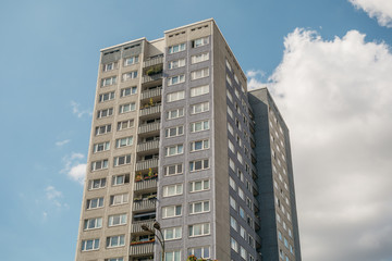 Fototapeta premium grey plattenbau building with big white clouds in the background