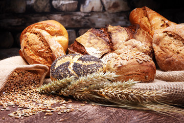 Different kinds of bread and bread rolls on wooden table