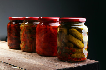 Jar with variety of pickled vegetables. Carrots, field garlic, parsley in glas. Preserved food. Fermented preserved vegetarian food concept. Canned food