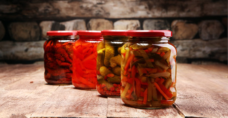 Jar with variety of pickled vegetables. Carrots, field garlic, parsley in glas. Preserved food. Fermented preserved vegetarian food concept. Canned food