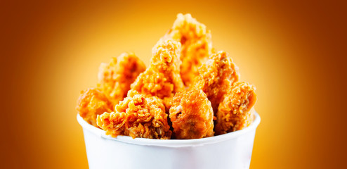 Fried chicken wings and legs. Bucket full of crispy kentucky fried chicken