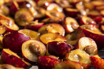 Sliced red plums for the cake , food or baking background, closeup