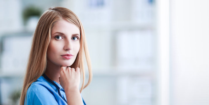 Doctor woman is standing in the near window