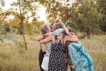 Girls stand in a circle embracing each other