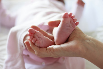 Obraz na płótnie Canvas Pies de bebé recién nacido sobre la mano de su madre