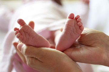 Pies de bebé recién nacido sobre las manos de su madre