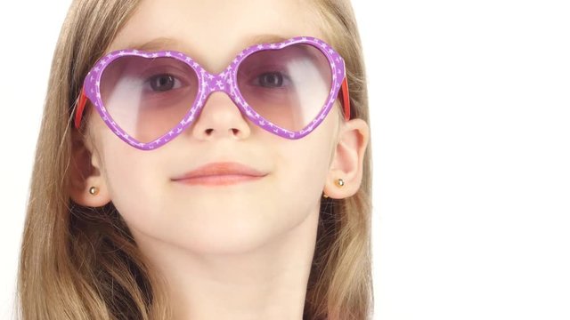 Child posing for video cameras with glasses. White background. Close up