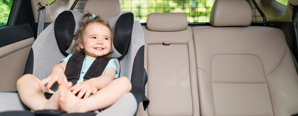 Infant baby girl buckled into her car seat.