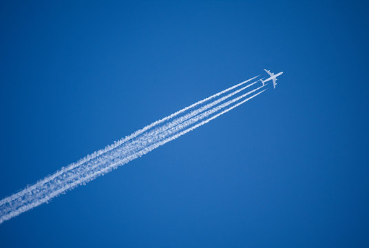 A jet plane flying overhead diagonally with condensation trail. © Mark