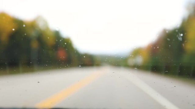 Rain drops on windshield while driving on highway