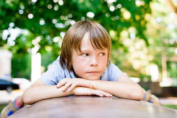 portrait of sad dreaming little boy outdoors