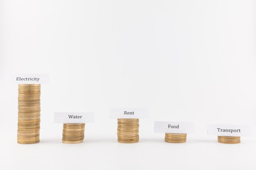 Big expenses on electricity. Coin stacks isolated in white background with labels