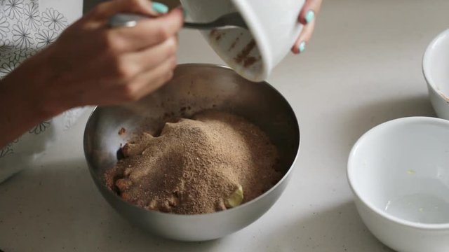 Woman adding ingredients to a bowl for cooking home made chocolate