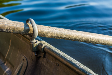 Row boat oar lock closeup in hole during summer with water