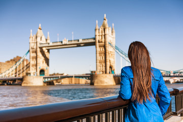 Tower Bridge London city travel woman tourist girl at Europe destination landmark famous attraction. Woman traveling in autumn season .