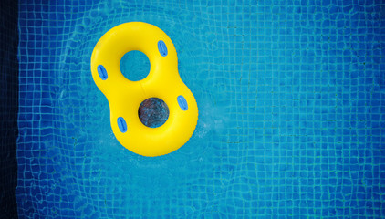 Yellow swim float, floating on swimming pool