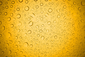 Water drops on yellow glass, Rain droplets on glass background.